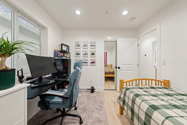 a bedroom with a bed and a computer on a desk