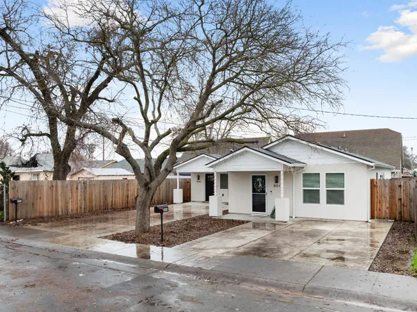 a front view of a house with a tree