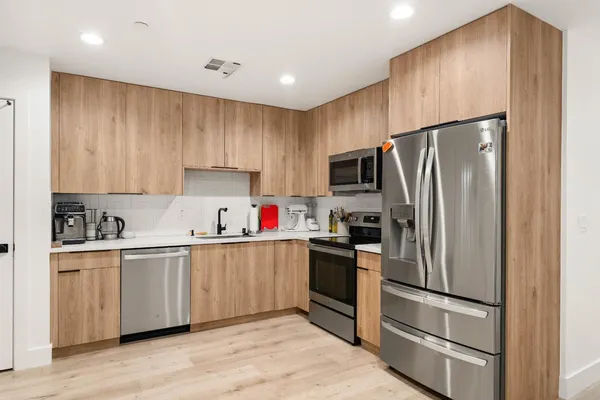 a kitchen with kitchen island a refrigerator sink and wooden cabinets