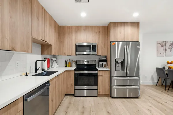 a kitchen with granite countertop a refrigerator and a stove top oven