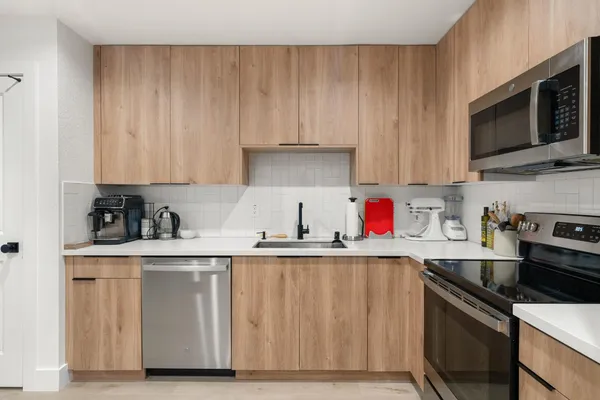 a kitchen with stainless steel appliances wooden cabinets and a sink