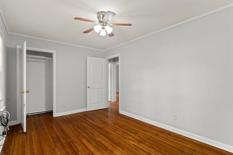 1042 Ivy Road Memphis, TN 38117 - Photo 17 of 27 an empty room with wooden floor and chandelier fan