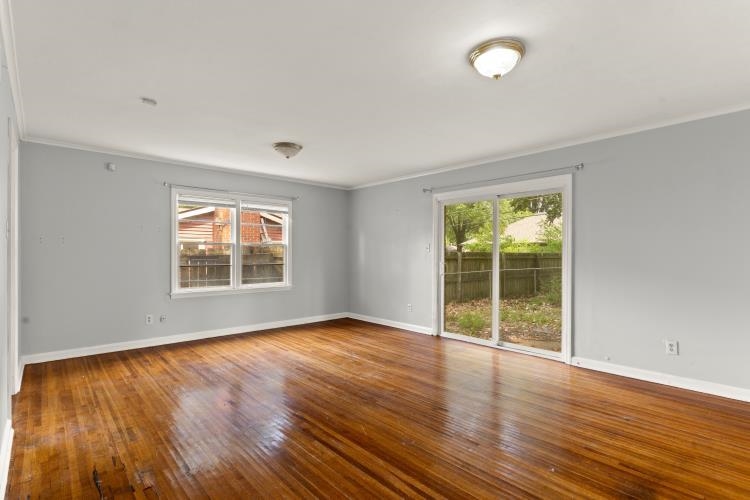 1042 Ivy Road Memphis, TN 38117 - Photo 4 of 27 an empty room with wooden floor and windows