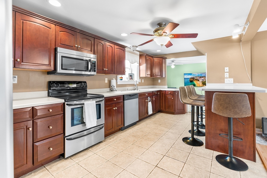 41 Pilgrim Road Weymouth, MA 02191 - Photo 1 of 27 a large kitchen with stainless steel appliances granite countertop a stove a sink dishwasher and a microwave oven with cabinets