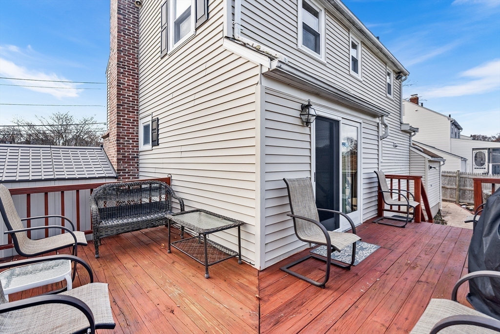 41 Pilgrim Road Weymouth, MA 02191 - Photo 24 of 27 a view of a roof deck with table and chairs a barbeque with wooden floor and fence