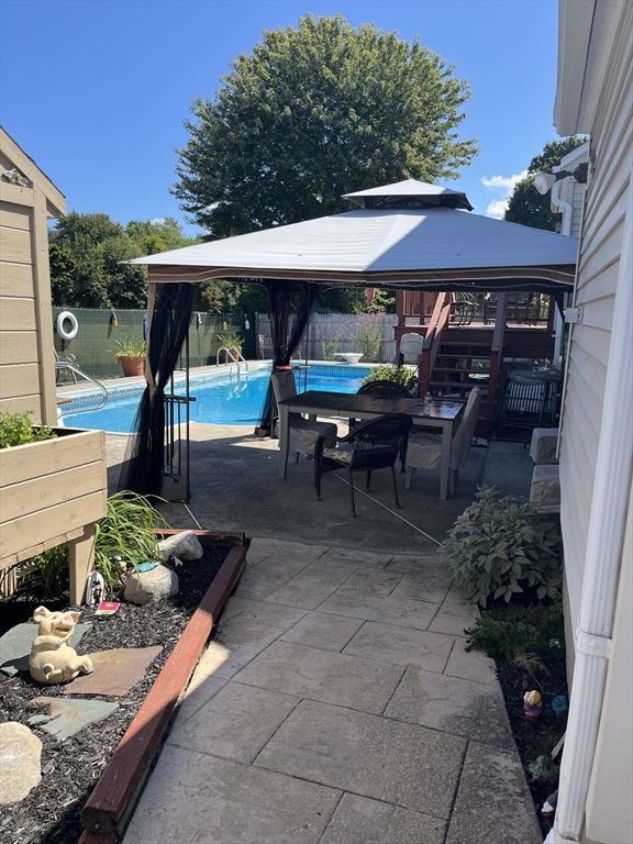41 Pilgrim Road Weymouth, MA 02191 - Photo 26 of 27 a view of a patio with table and chairs potted plants