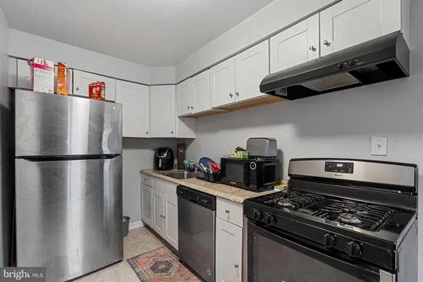 a kitchen with stainless steel appliances granite countertop a refrigerator and a stove