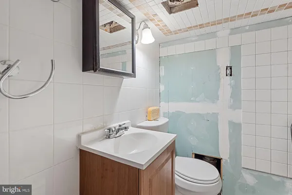 a bathroom with a sink toilet a mirror and shower