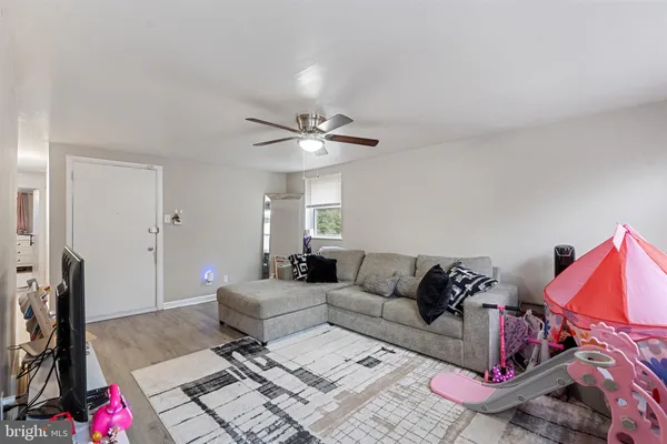 a living room with furniture a rug and white walls