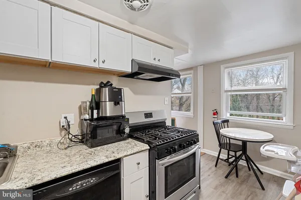 a kitchen with granite countertop a stove and a sink