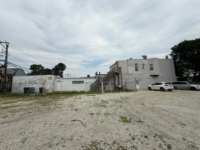 a view of a dry yard with a house in the background