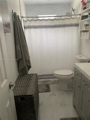 a bathroom with a granite countertop toilet and a sink