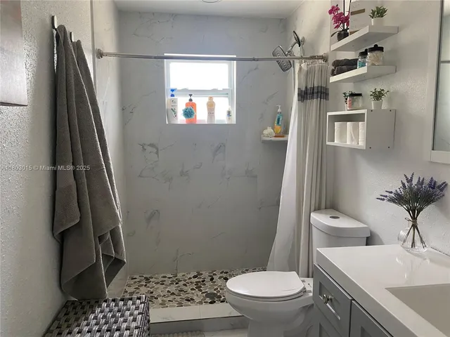 a bathroom with a sink toilet and shower