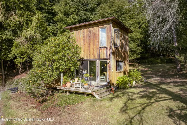 a view of a house with large trees and plants