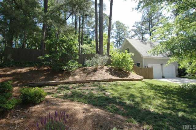 8109 Running Cedar Trail Raleigh, NC 27615 - Photo 3 of 11 a backyard of a house with large trees and plants