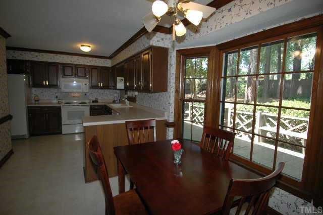 8109 Running Cedar Trail Raleigh, NC 27615 - Photo 4 of 11 a kitchen with a table chairs stove and refrigerator