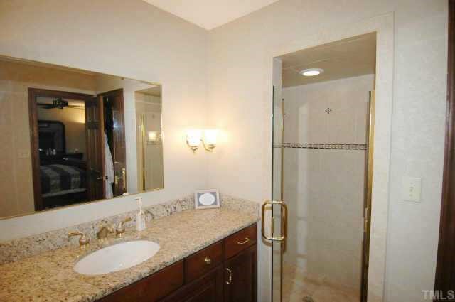 8109 Running Cedar Trail Raleigh, NC 27615 - Photo 8 of 11 a bathroom with a granite countertop sink mirror and shower