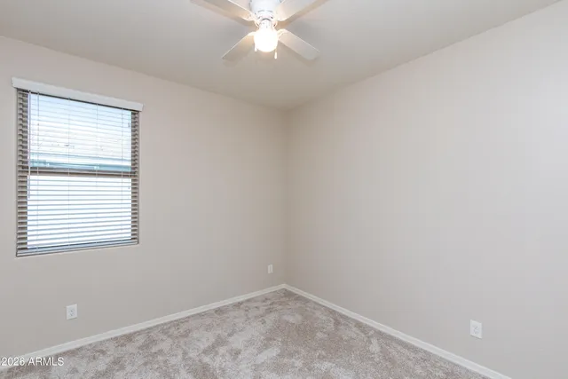 an empty room with a window and a fan