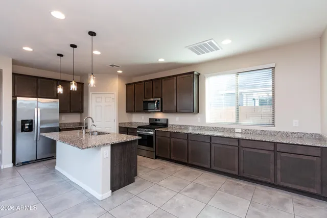 a kitchen with stainless steel appliances granite countertop a sink counter space cabinets and a large window