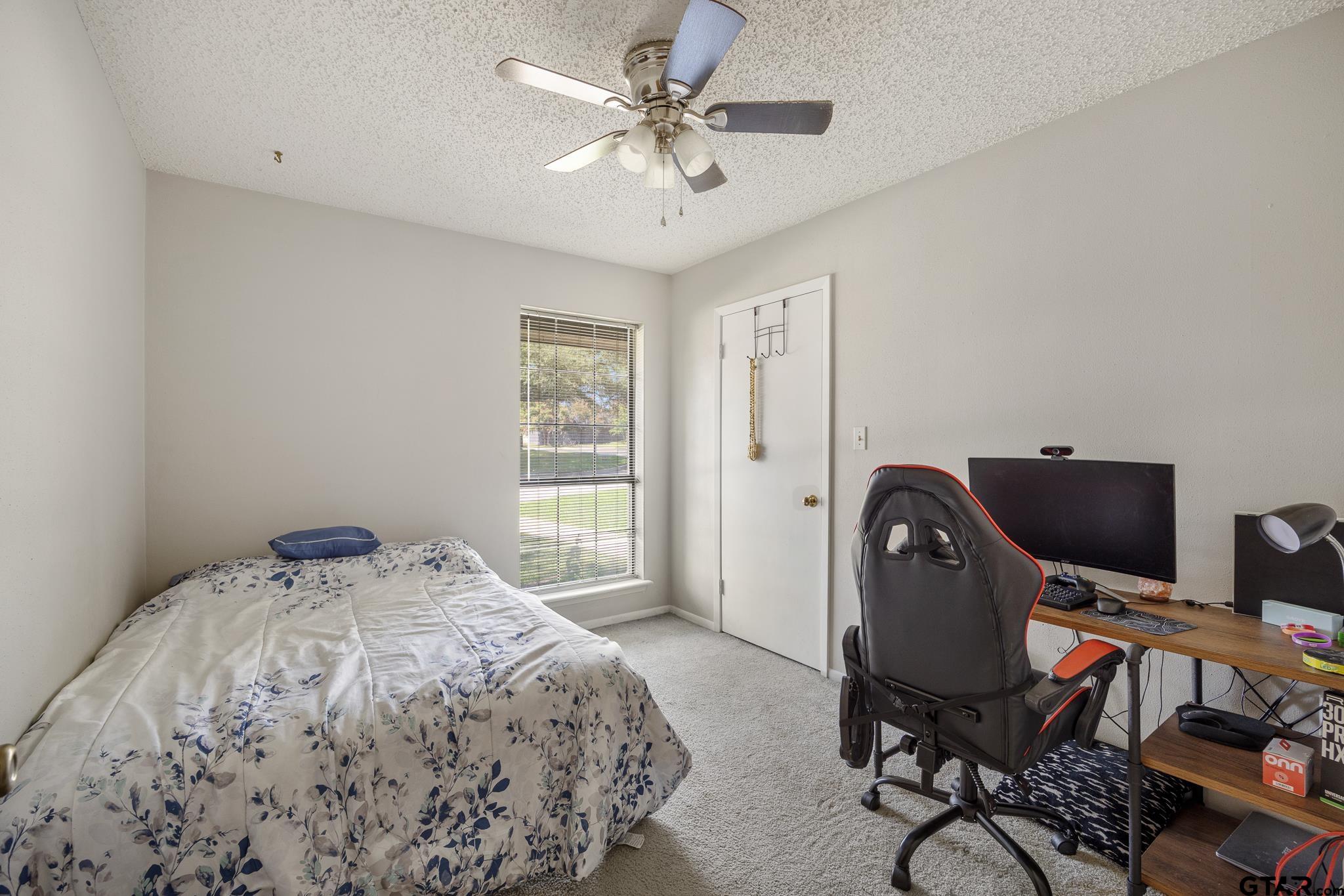802 Carriage Drive Tyler, TX 75703 - Photo 13 of 21 a bedroom with a bed and a desk