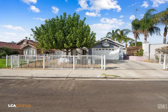 a front view of a house with a garden and trees