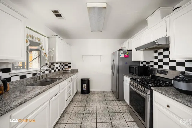 a kitchen with stainless steel appliances granite countertop a stove and a sink