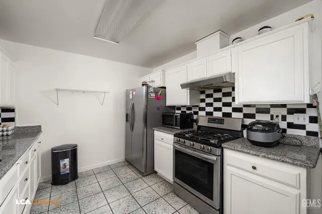 a kitchen with stainless steel appliances a stove a sink and a refrigerator