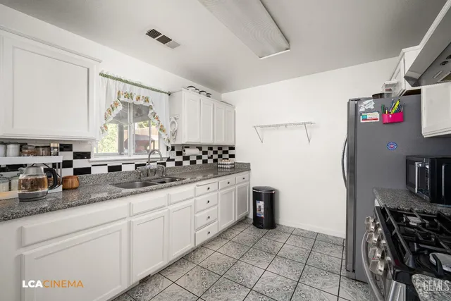 a kitchen with stainless steel appliances granite countertop a sink stove and cabinets