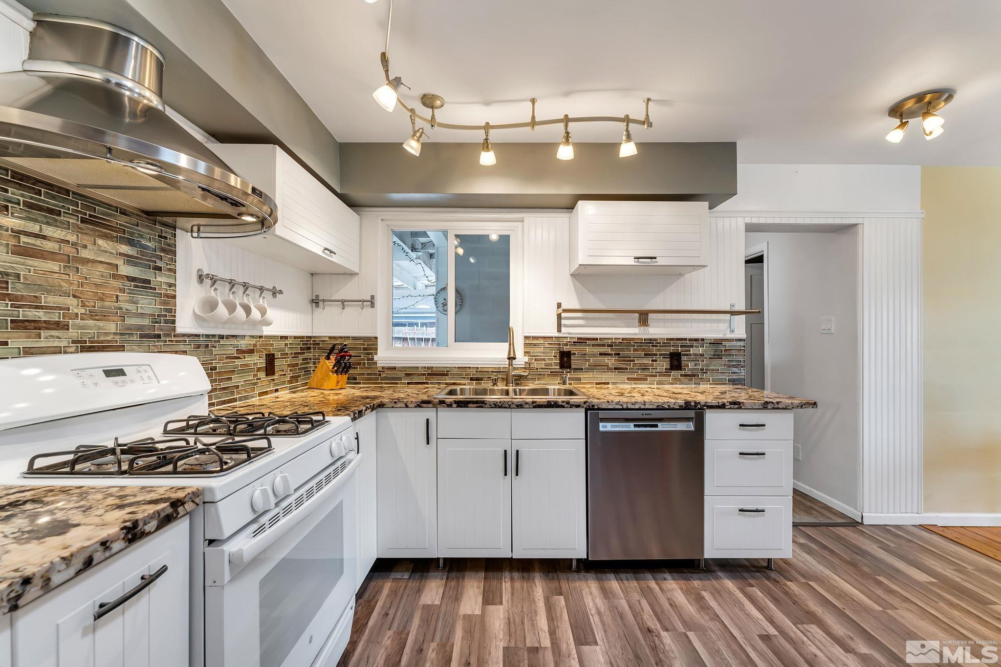 a kitchen with stainless steel appliances granite countertop a stove and a white cabinets