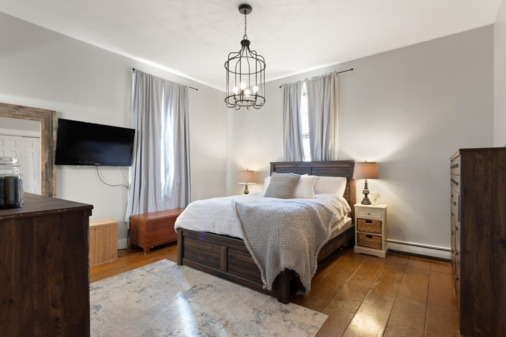 22 Sanderson Road Littleton, MA 01460 - Photo 19 of 30 a spacious bedroom with a bed and a flat screen tv