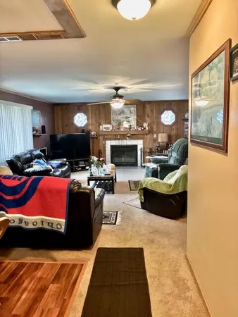 a living room with furniture a fireplace and a flat screen tv
