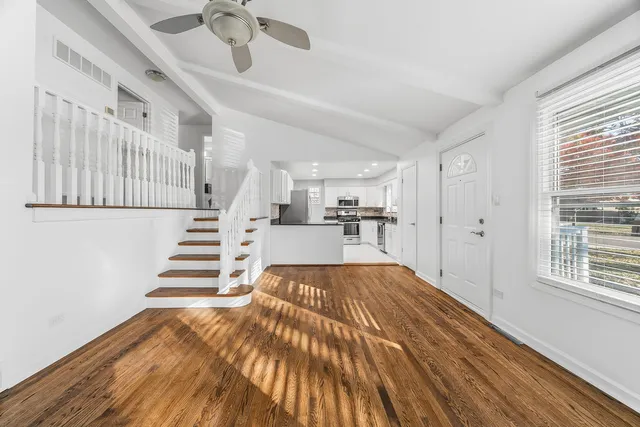 a view of entryway and kitchen with wooden floor
