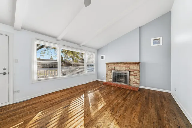 a view of empty room with wooden floor fireplace and windows