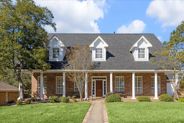 front view of house with a yard and potted plants