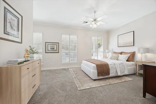 a spacious bedroom with a large bed and a chandelier fan