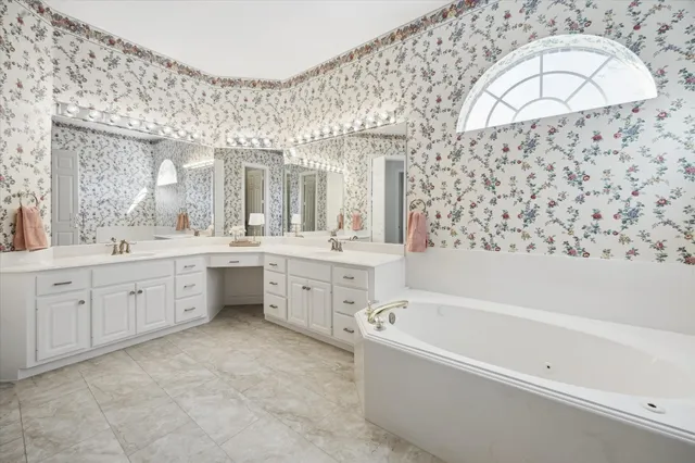 a bathroom with a double vanity sink mirror and bathtub