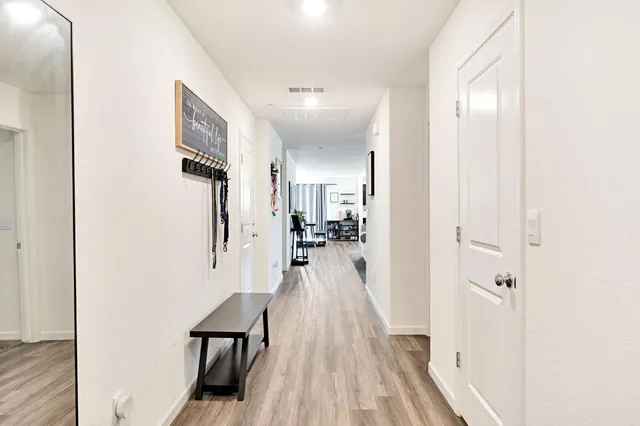 a view of a hallway with wooden floor and staircase