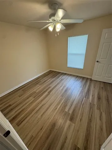 a view of a livingroom with wooden floor and chandelier fan