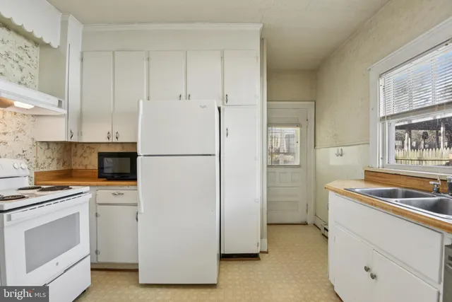 a kitchen with a refrigerator stove and white cabinets