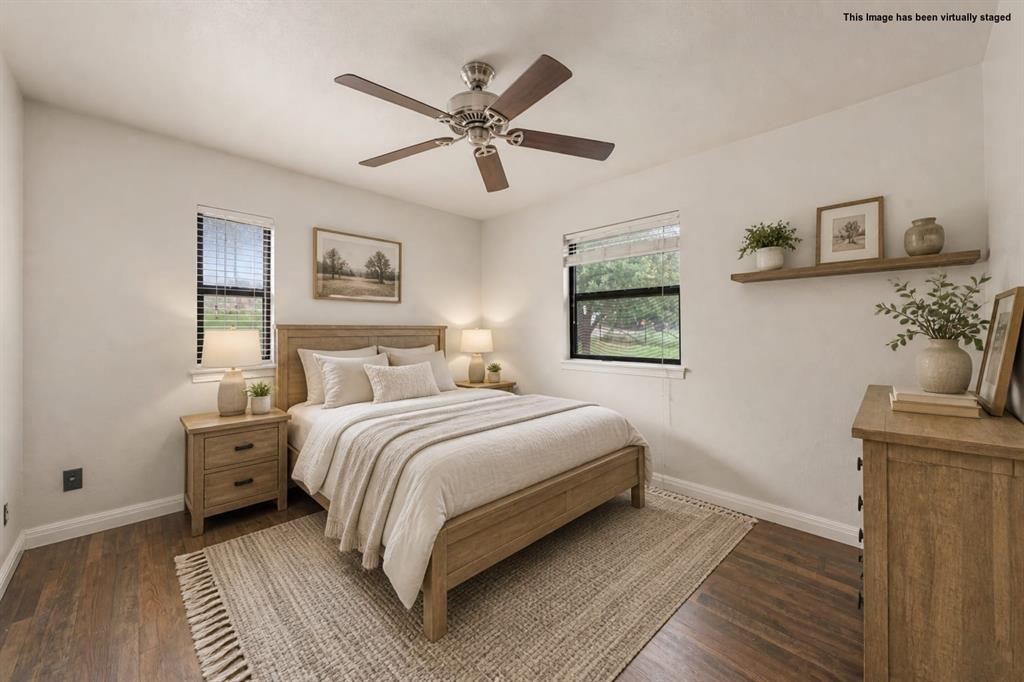 608 West Spring Street West, TX 76691 - Photo 14 of 23 Wood-finish flooring with light-toned walls, ceiling fan with brown blades, and two windows with horizontal blinds