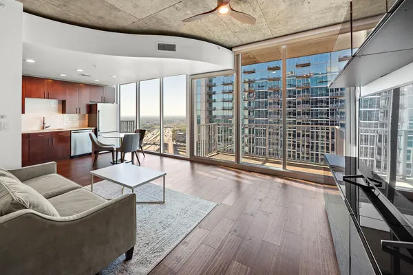 a living room with furniture a wooden floor and next to a window