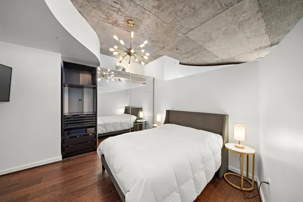 a bedroom with a bed and wooden floor