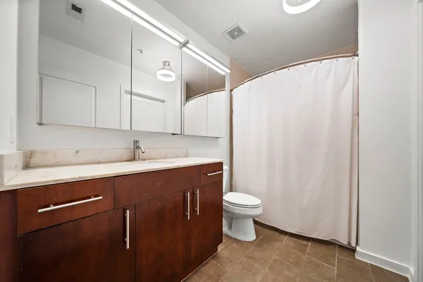 a bathroom with a sink a toilet and a mirror
