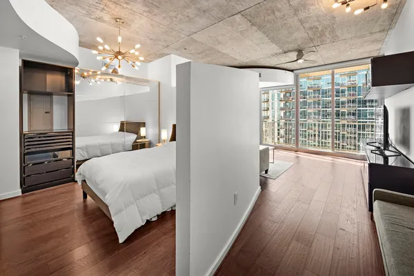 a bedroom with a bed and wooden floor