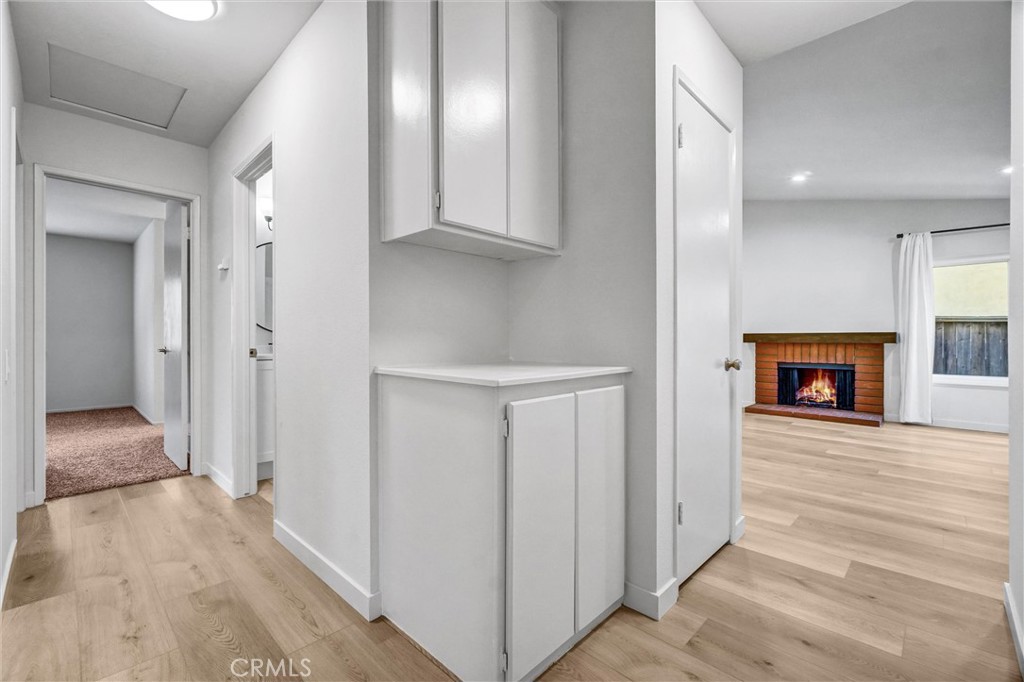 27122 Valleymont Road Lake Forest, CA 92630 - Photo 13 of 35 a view of a hallway with wooden floor and a fireplace