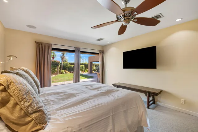 a bedroom with a bed tv and a window