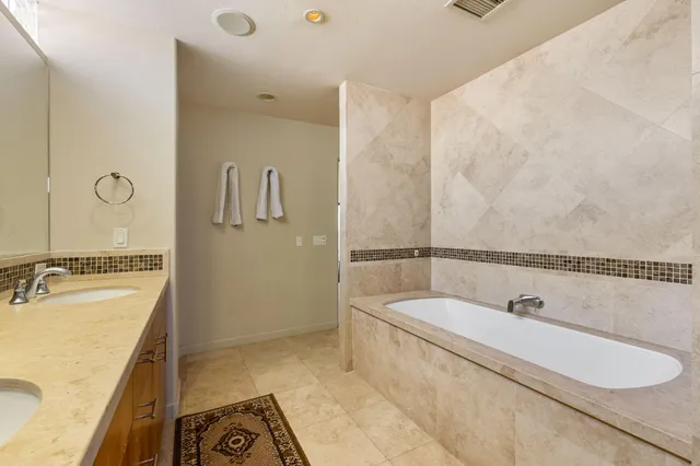 a bathroom with a tub sink and mirror