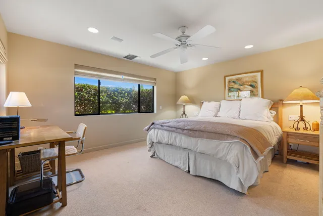 a spacious bedroom with a large bed and a chandelier