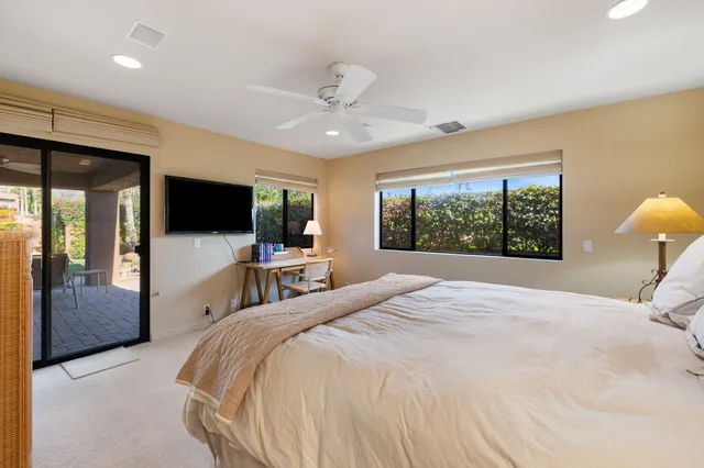 a bedroom with a large bed and a flat screen tv