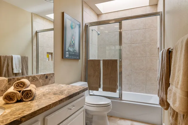 a bathroom with a granite countertop sink toilet and shower